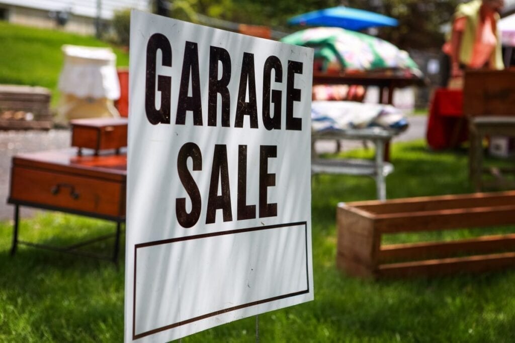 Garage sale sign on grass lawn