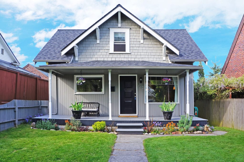 gray house with plants on front porch